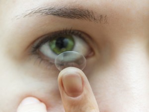 Woman putting contact lens into eye